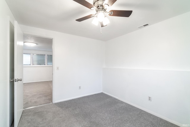 carpeted spare room with ceiling fan