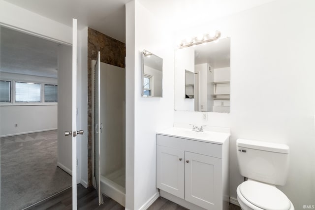 bathroom with an enclosed shower, vanity, and toilet