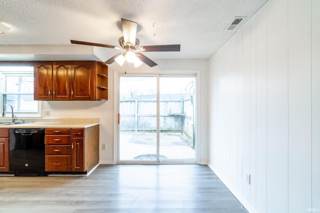 kitchen featuring plenty of natural light, light hardwood / wood-style floors, and black dishwasher