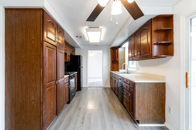 kitchen with sink, light hardwood / wood-style flooring, black range with gas stovetop, dishwasher, and ceiling fan