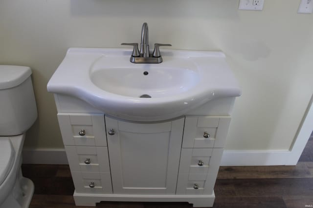 bathroom with hardwood / wood-style flooring, vanity, and toilet