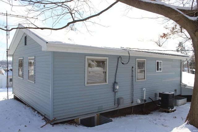 view of snow covered exterior featuring central AC