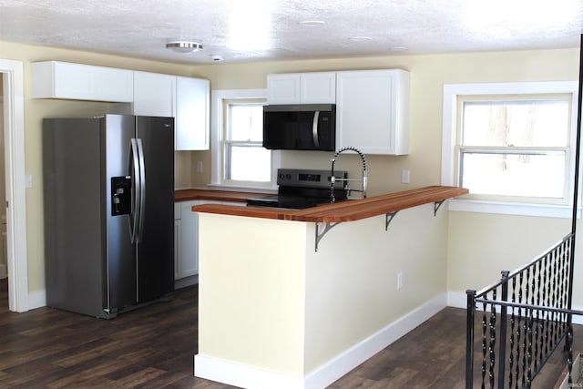 kitchen featuring a kitchen bar, sink, dark hardwood / wood-style flooring, stainless steel appliances, and white cabinets