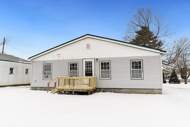 snow covered house featuring a wooden deck