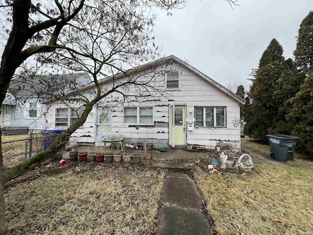 bungalow-style house featuring a front lawn