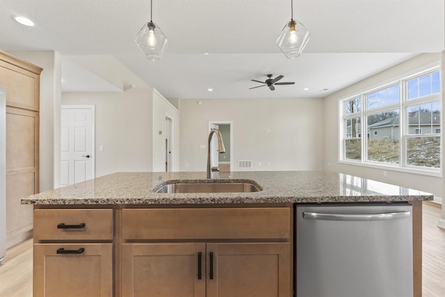 kitchen with sink, decorative light fixtures, light stone countertops, and dishwasher