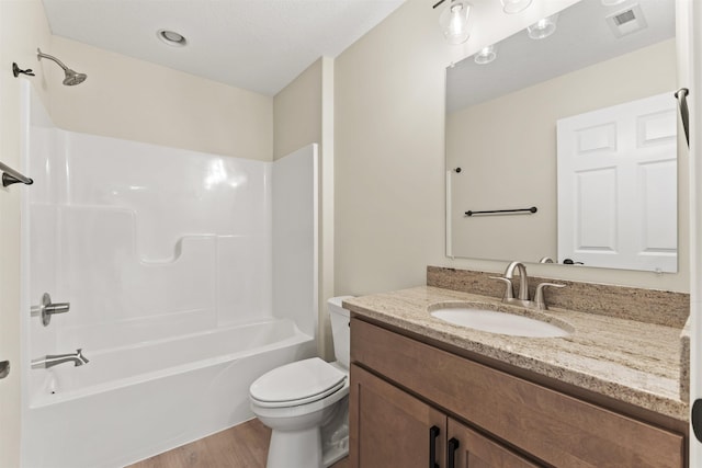 full bathroom with vanity, hardwood / wood-style flooring, bathtub / shower combination, and toilet