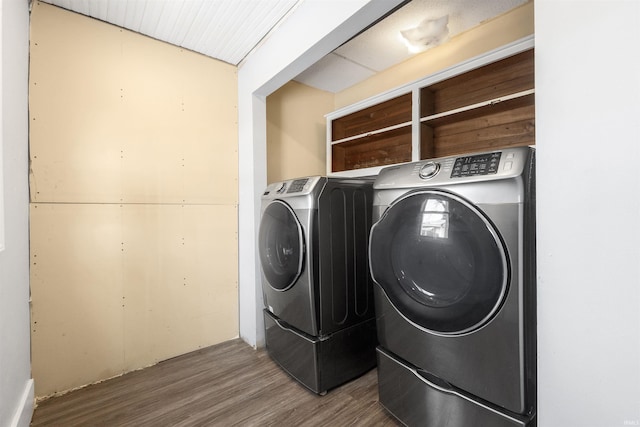 laundry room with wood-type flooring and washing machine and clothes dryer