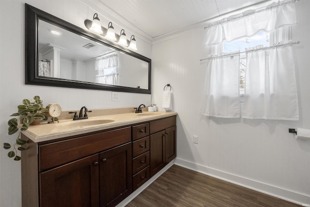 bathroom with vanity, ornamental molding, and hardwood / wood-style floors