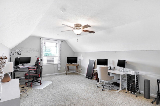 office area featuring ceiling fan, vaulted ceiling, light colored carpet, and a textured ceiling