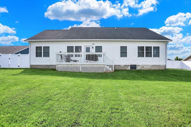 back of house featuring a deck and a lawn