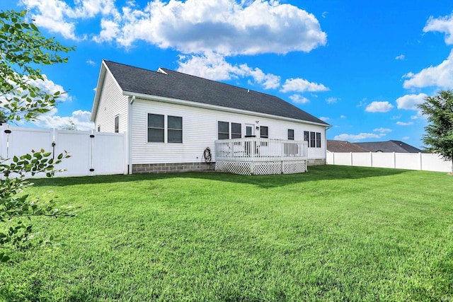 rear view of property featuring a wooden deck and a yard