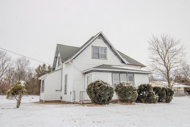 view of snowy exterior featuring a shingled roof