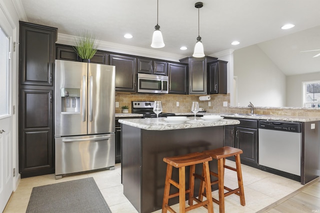 kitchen featuring stainless steel appliances, a center island, pendant lighting, and backsplash