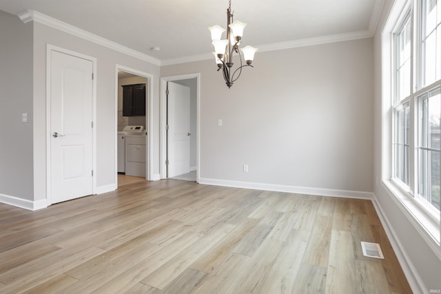 unfurnished dining area with crown molding, a chandelier, washing machine and clothes dryer, and light wood-type flooring