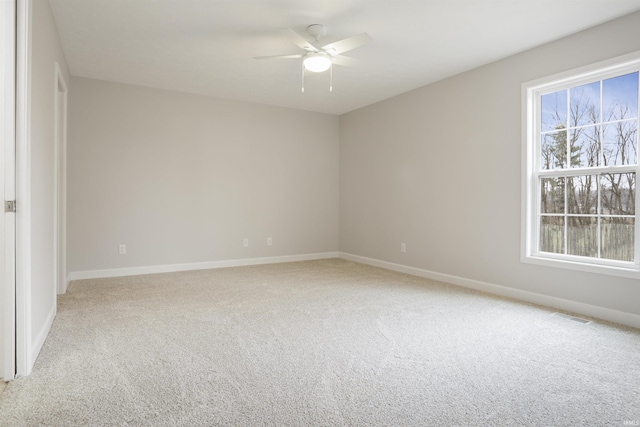 carpeted spare room with ceiling fan and a healthy amount of sunlight