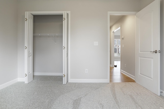 unfurnished bedroom featuring light colored carpet and a closet