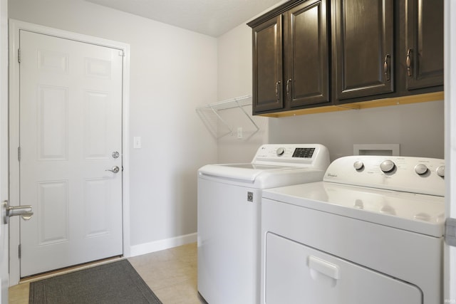 clothes washing area featuring cabinets and washer and dryer