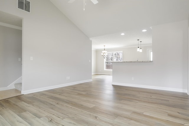 spare room featuring ornamental molding, ceiling fan with notable chandelier, and light hardwood / wood-style floors