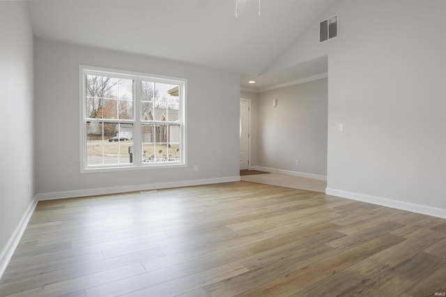 spare room featuring light hardwood / wood-style flooring and high vaulted ceiling