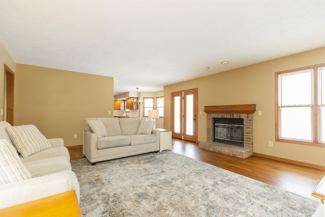 living room featuring hardwood / wood-style flooring and a brick fireplace