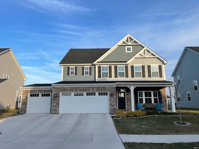 craftsman inspired home with a garage, covered porch, and a front lawn