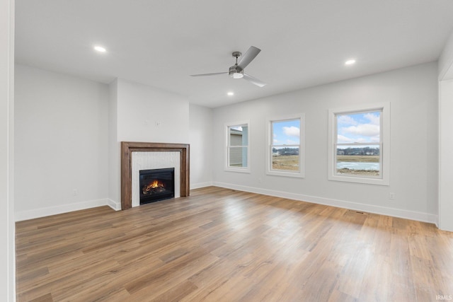 unfurnished living room with ceiling fan and light hardwood / wood-style flooring