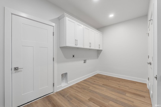 laundry room with gas dryer hookup, cabinets, hookup for an electric dryer, and light hardwood / wood-style floors