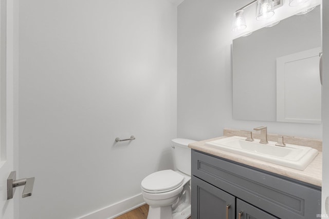 bathroom with hardwood / wood-style flooring, vanity, and toilet