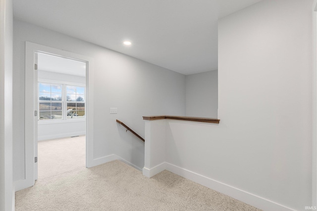 hall with light colored carpet