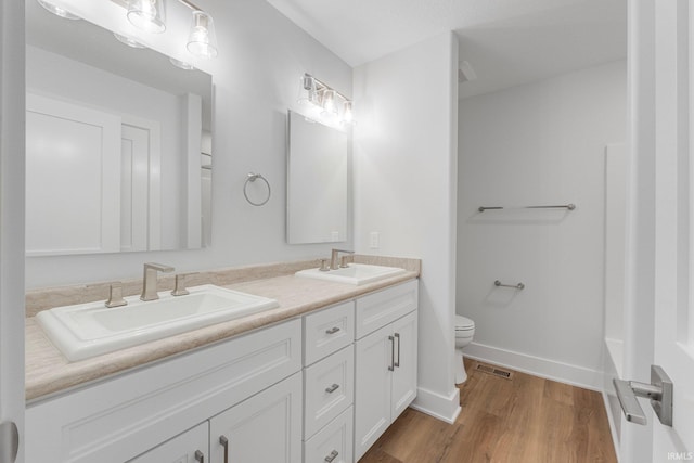 bathroom featuring vanity, hardwood / wood-style flooring, and toilet