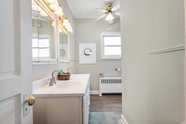 bathroom featuring hardwood / wood-style flooring, vanity, radiator heating unit, and ceiling fan