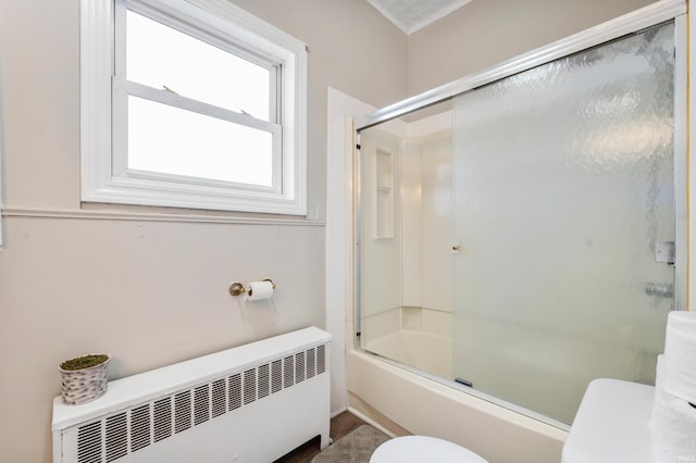 bathroom with shower / bath combination with glass door, toilet, and radiator