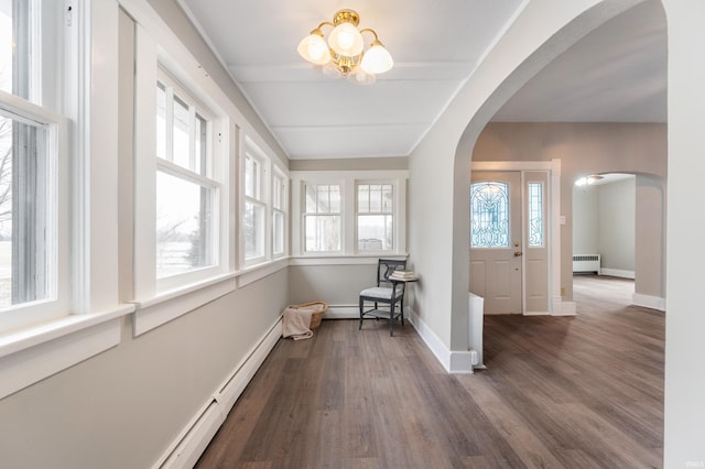 entrance foyer with hardwood / wood-style flooring, radiator, and an inviting chandelier