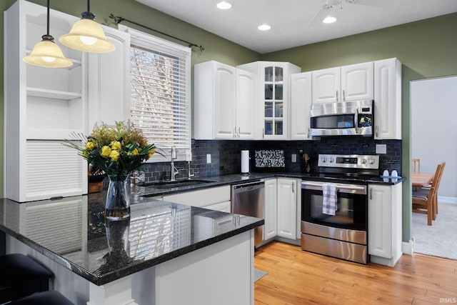 kitchen featuring sink, white cabinetry, hanging light fixtures, kitchen peninsula, and stainless steel appliances