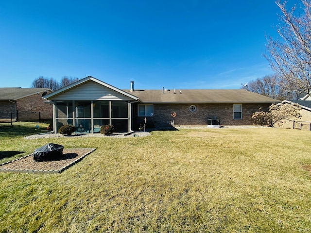 rear view of house with a yard and a sunroom