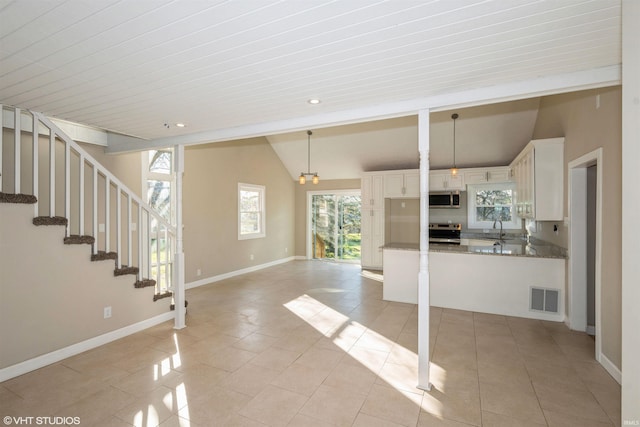 interior space featuring sink, light tile patterned floors, and vaulted ceiling