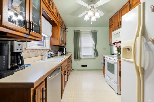 kitchen featuring tasteful backsplash, ceiling fan, sink, and white appliances