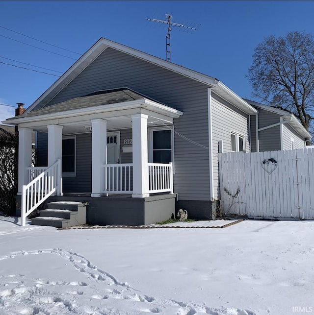 view of front of property with a porch and fence