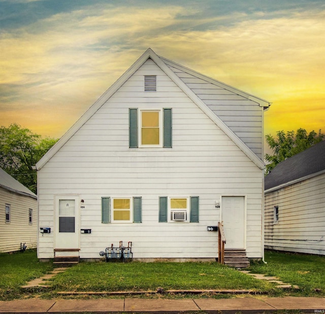 back house at dusk featuring a yard