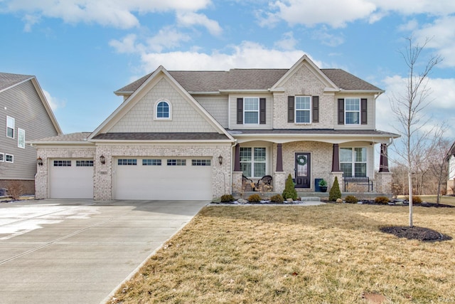 craftsman-style house featuring a garage, a front yard, and covered porch