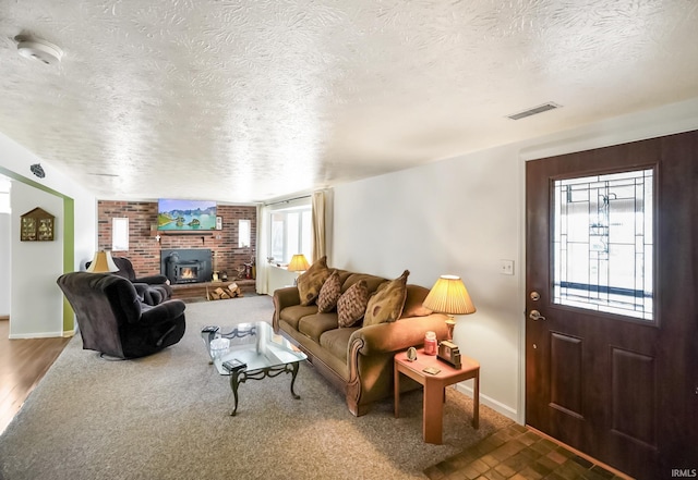 living room featuring a brick fireplace and a textured ceiling