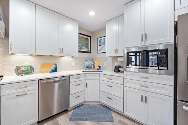 kitchen with white cabinetry, appliances with stainless steel finishes, sink, and tasteful backsplash