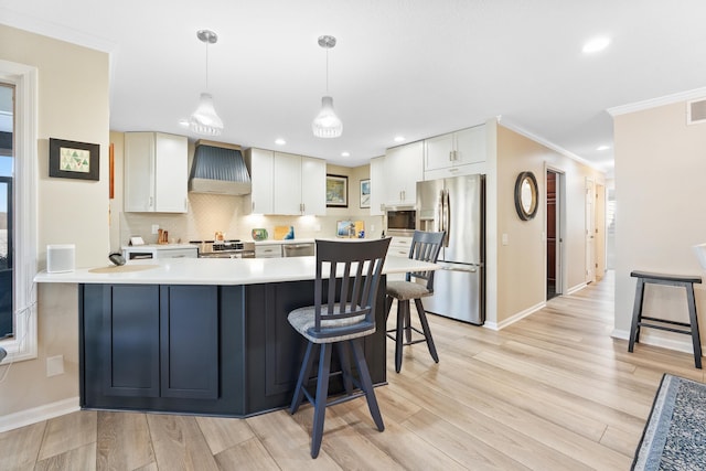 kitchen with white cabinetry, pendant lighting, custom exhaust hood, and appliances with stainless steel finishes