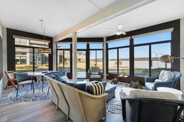 sunroom / solarium with a water view and ceiling fan