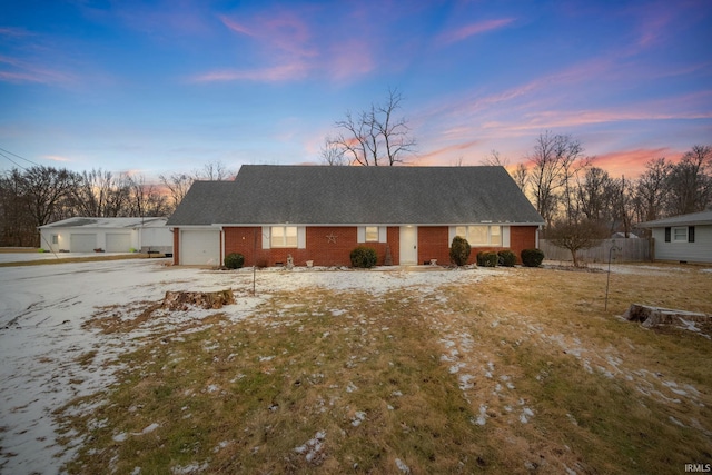 ranch-style home with brick siding, an attached garage, driveway, and roof with shingles