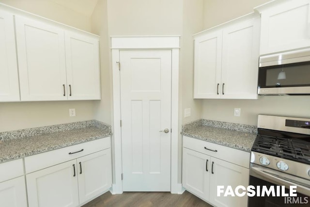 kitchen with stainless steel appliances, dark wood-type flooring, white cabinets, and light stone counters