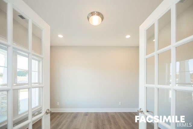 unfurnished room featuring hardwood / wood-style floors and french doors