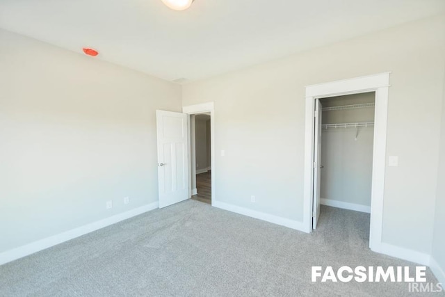 unfurnished bedroom with a walk in closet, light carpet, and a closet