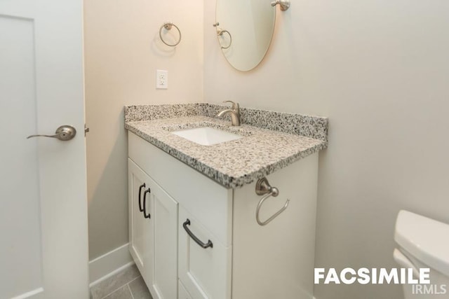 bathroom featuring vanity, tile patterned floors, and toilet